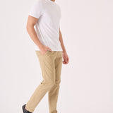 A man walking in stylish men's beige chinos slim fit with a white t-shirt.
