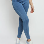 Close up of the skinny fit and fabric texture of the mid blue denim jeggings for women.