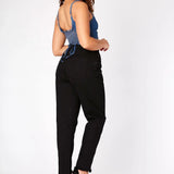 Rear view of a woman wearing black high waisted denim jeans with a flattering straight leg cut.
