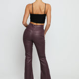 Rear view of high waisted maroon skinny bootcut jeans showing the flattering fit and coated finish.