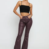 A full length shot of the maroon skinny bootcut jeans styled with black heels for a chic look.