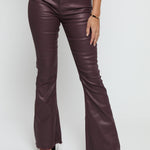 Close up of the maroon skinny bootcut jeans showing the unique coated sheen and stitching.