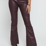 Close up of the maroon skinny bootcut jeans showing the unique coated sheen and stitching.